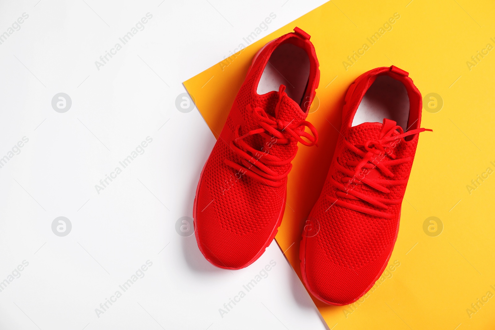 Pair of red sneakers on color background, flat lay. Space for text Photo of Pair of red sneakers on color background, flat lay. Space for text