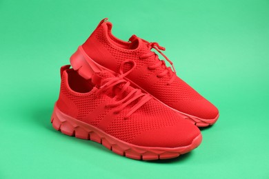 Photo of Pair of red sneakers on green background