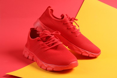 Photo of Pair of red sneakers on color background