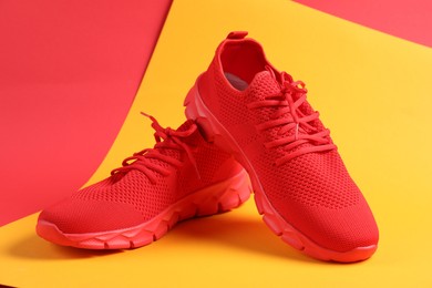 Photo of Pair of red sneakers on color background