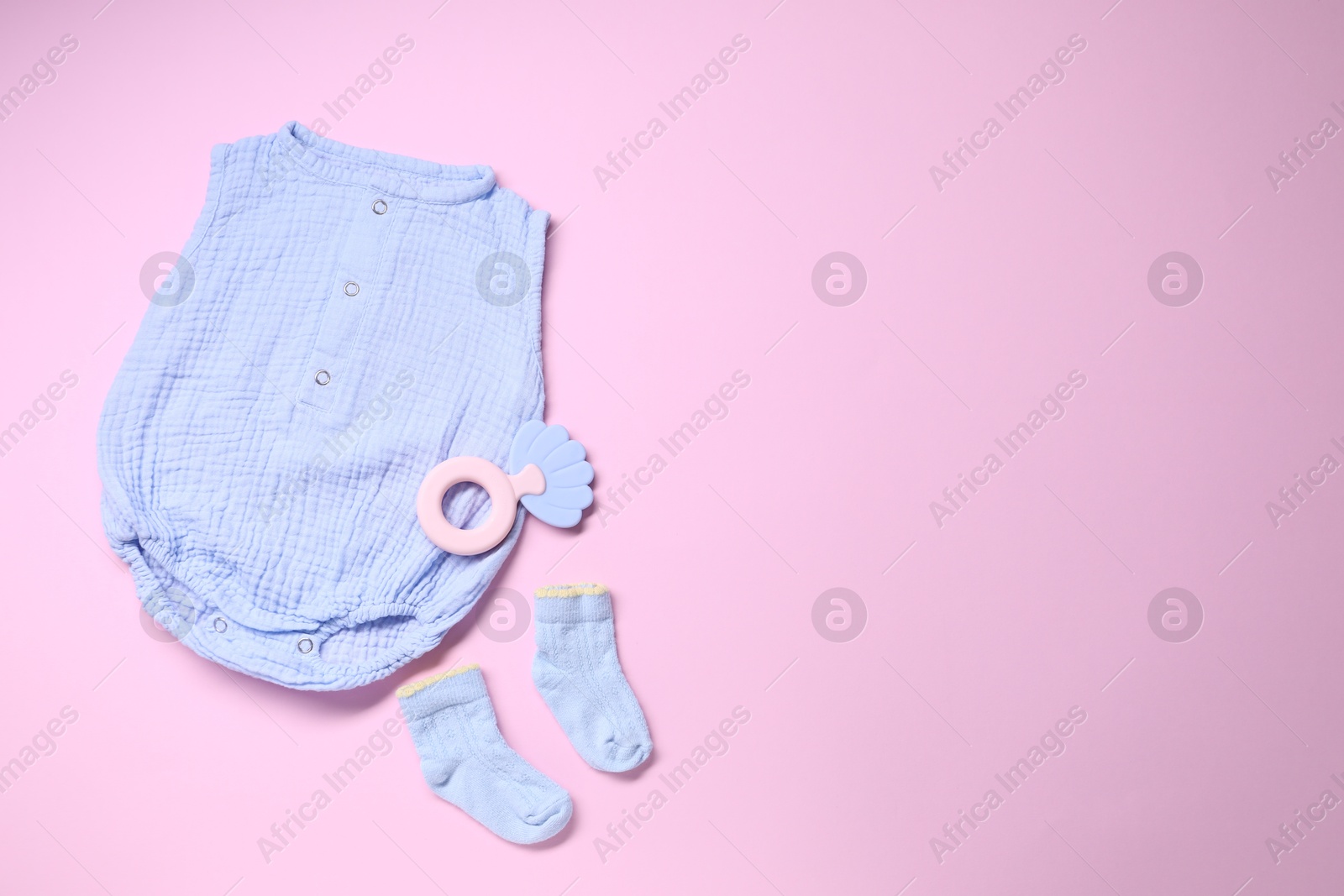 Photo of Baby clothes and accessory on pink background, flat lay. Space for text