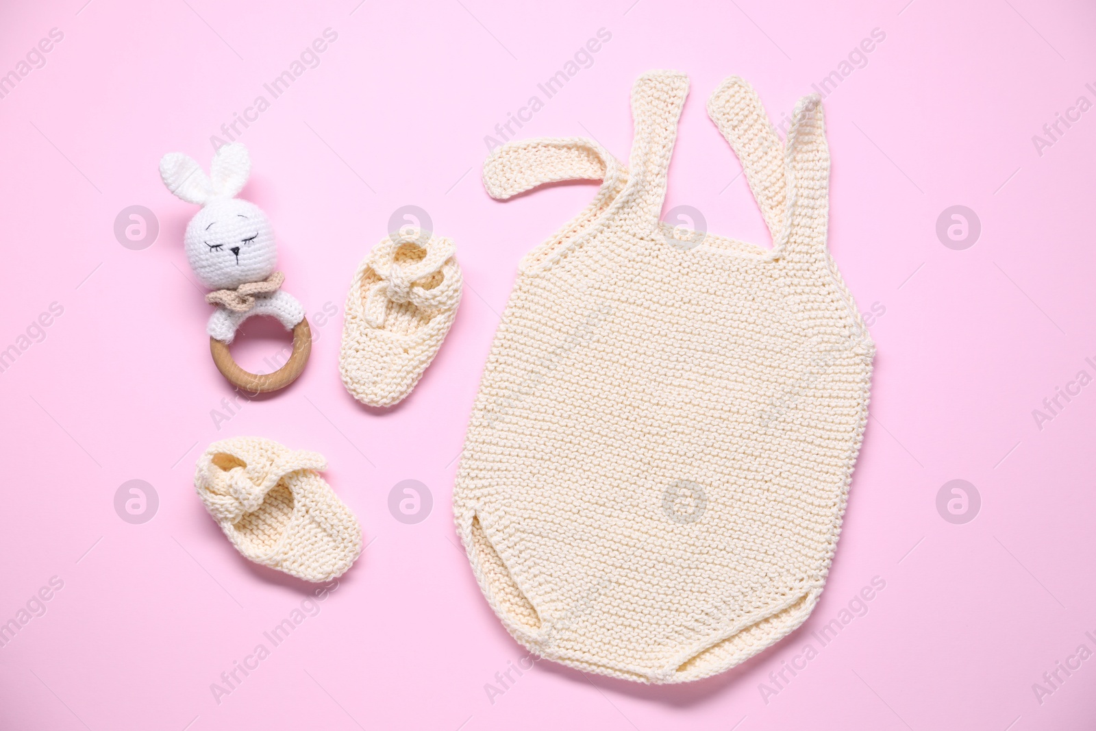 Photo of Baby clothes and accessory on pink background, flat lay