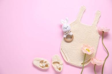 Photo of Baby clothes, flowers and accessory on pink background, flat lay. Space for text