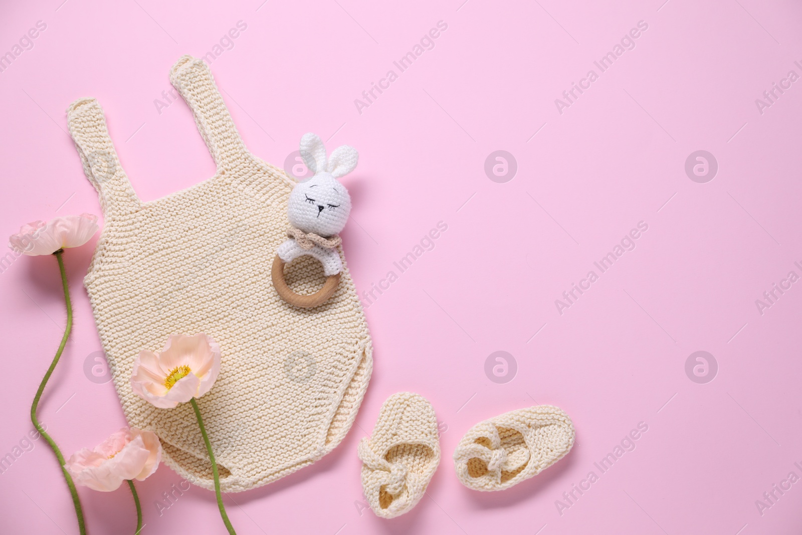 Baby clothes, flowers and accessory on pink background, flat lay. Space for text Photo of Baby clothes, flowers and accessory on pink background, flat lay. Space for text