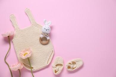 Photo of Baby clothes, flowers and accessory on pink background, flat lay. Space for text
