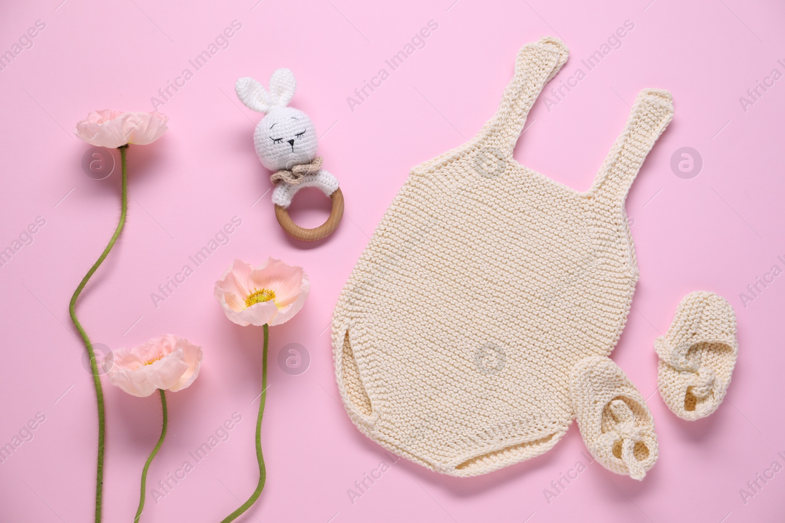 Baby clothes, flowers and accessory on pink background, flat lay Photo of Baby clothes, flowers and accessory on pink background, flat lay