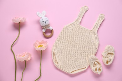 Photo of Baby clothes, flowers and accessory on pink background, flat lay