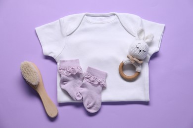 Photo of Baby clothes and accessories on violet background, flat lay