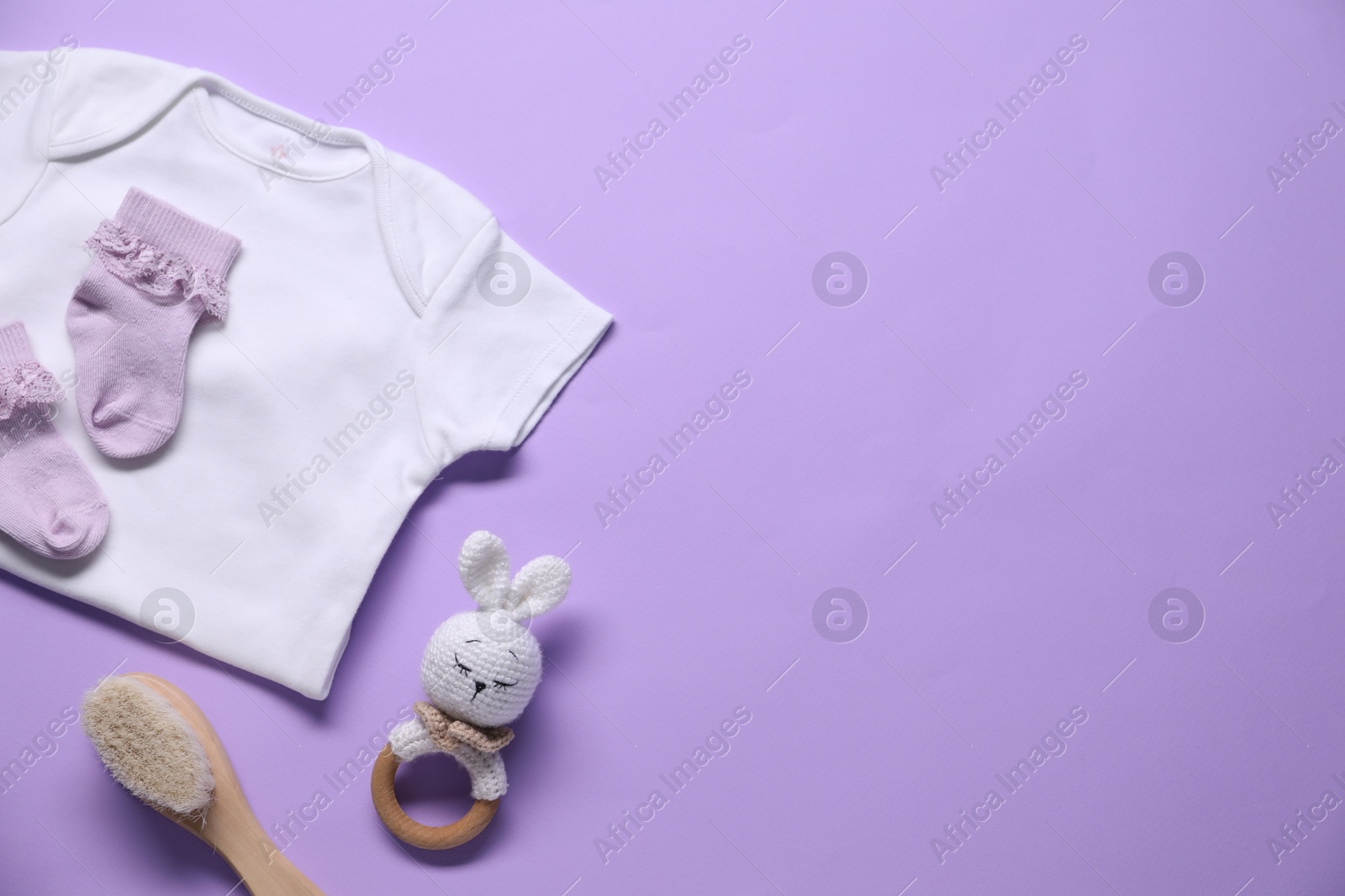 Photo of Baby clothes and accessories on violet background, flat lay. Space for text