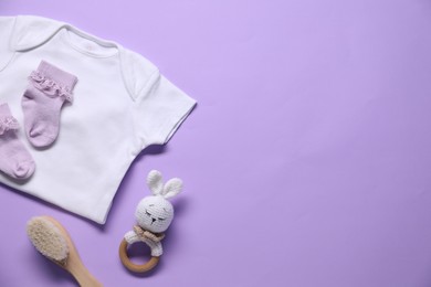 Photo of Baby clothes and accessories on violet background, flat lay. Space for text