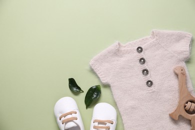 Photo of Baby clothes and accessory on light green background, flat lay. Space for text