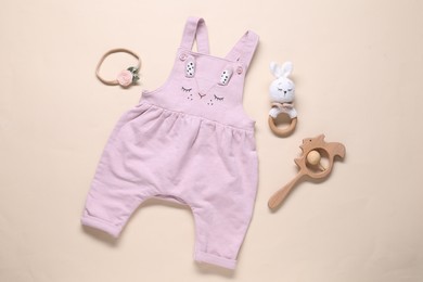 Photo of Baby jumpsuit and accessories on beige background, flat lay