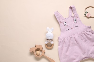 Photo of Baby jumpsuit and accessories on beige background, flat lay. Space for text