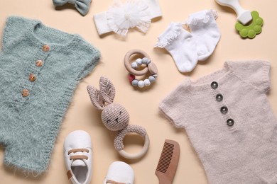 Photo of Baby clothes and accessories on beige background, flat lay