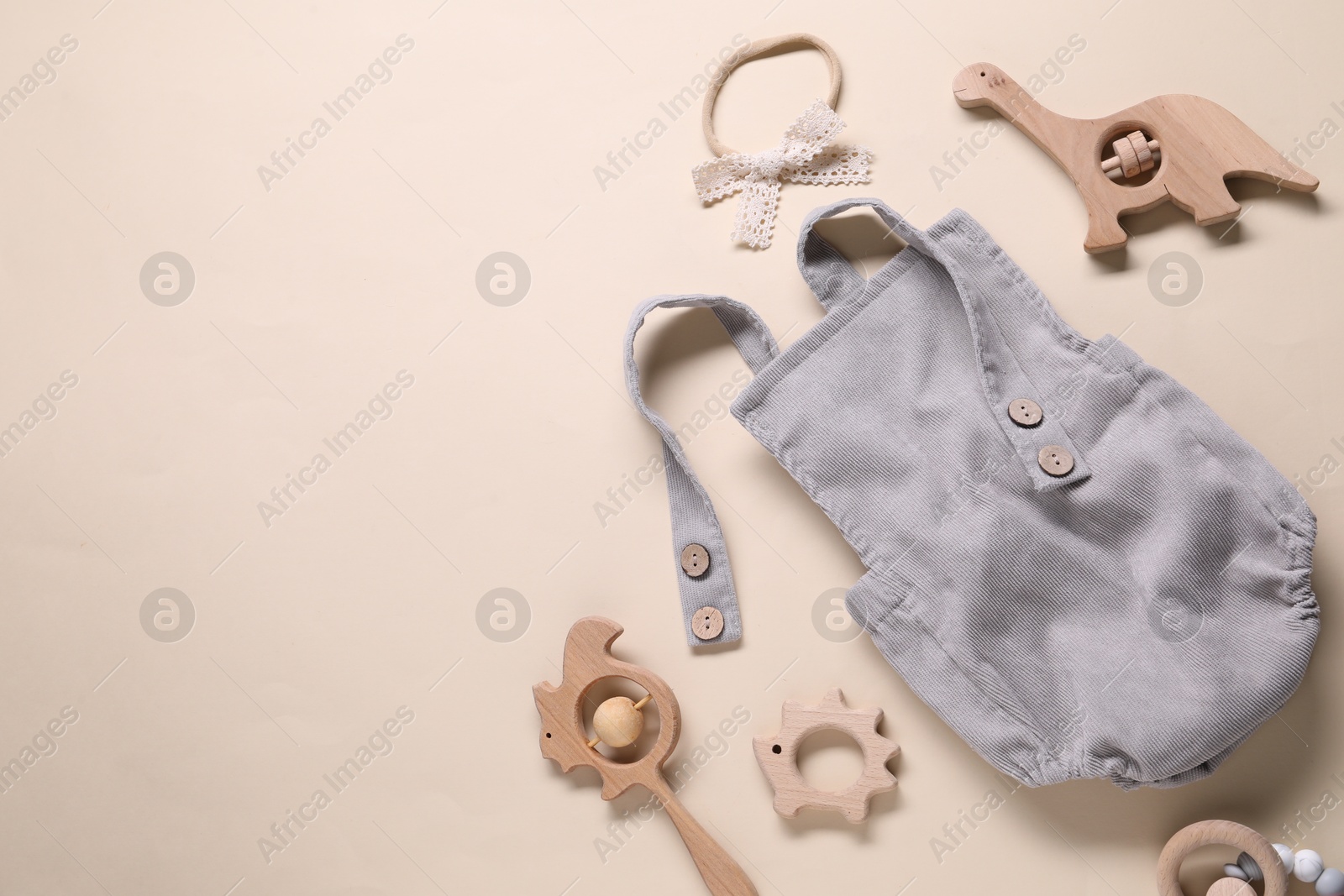 Baby onesie and accessories on beige background, flat lay. Space for text Photo of Baby onesie and accessories on beige background, flat lay. Space for text