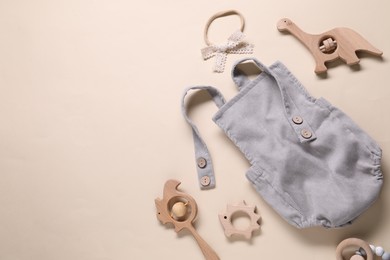 Photo of Baby onesie and accessories on beige background, flat lay. Space for text