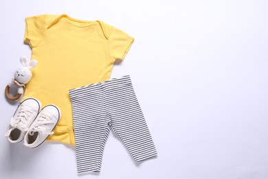 Photo of Baby clothes and accessory on white background, flat lay. Space for text