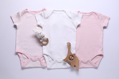 Photo of Baby onesies and accessories on white background, flat lay