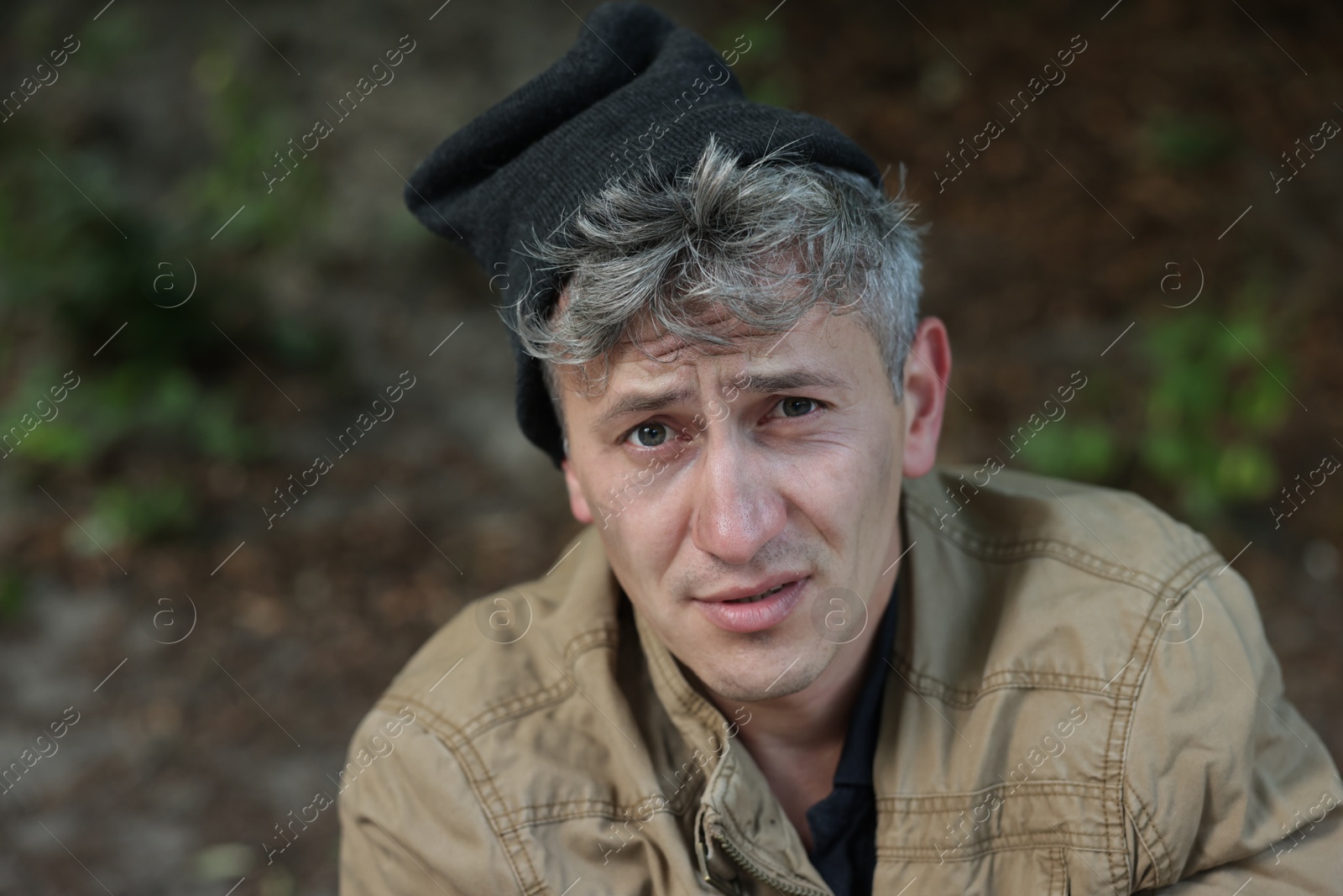Photo of Portrait of poor homeless man outdoors, space for text