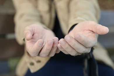 Photo of Homeless man begging for money outdoors, selective focus