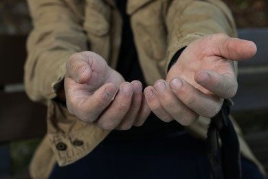 Photo of Homeless man begging for money outdoors, closeup