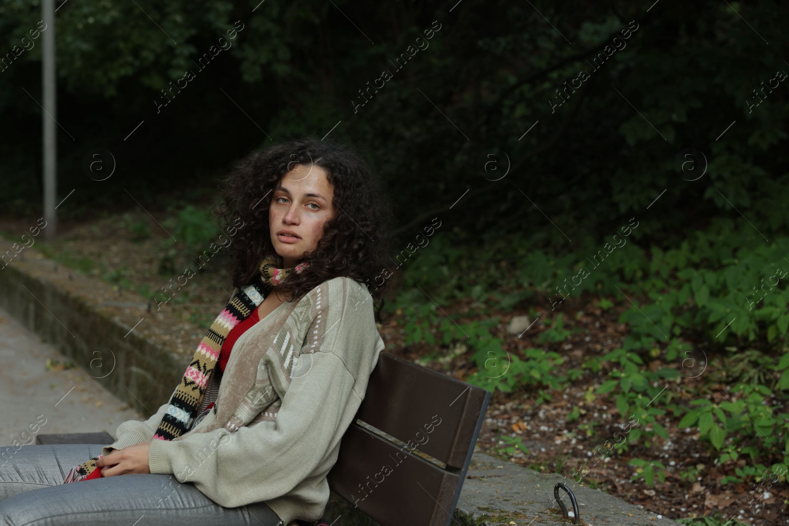 Photo of Homeless woman sitting on bench in park