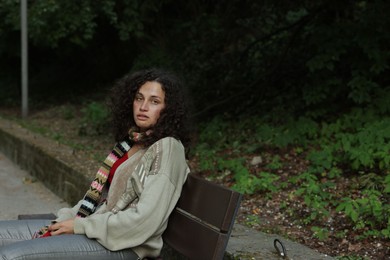 Photo of Homeless woman sitting on bench in park