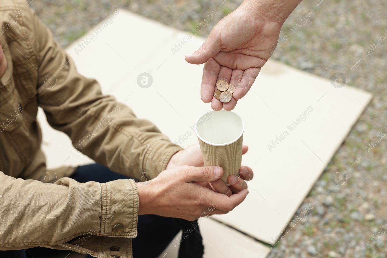 Man giving money to homeless person outdoors, closeup Photo of Man giving money to homeless person outdoors, closeup