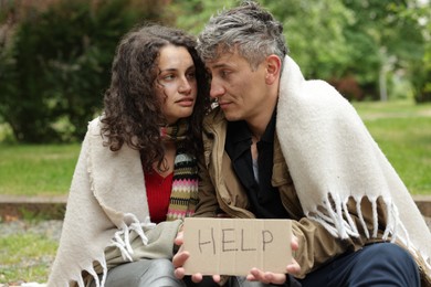 Photo of Homeless people with sign Help in park