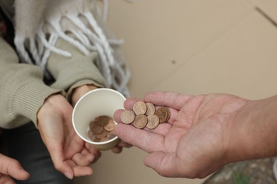Photo of Man giving money to homeless people outdoors, above view