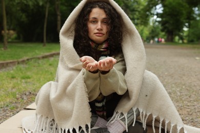 Photo of Homeless woman begging for money in park