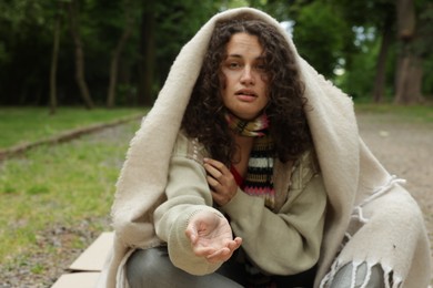 Photo of Homeless woman begging for money in park
