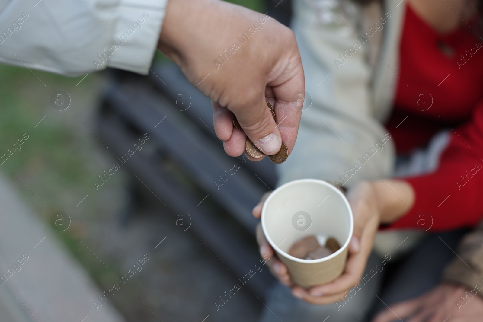 Photo of Man giving money to homeless people outdoors, closeup