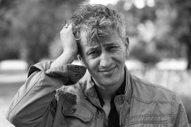 Photo of Portrait of homeless man outdoors. Black and white effect
