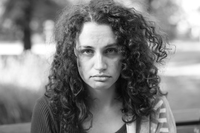 Photo of Portrait of homeless woman outdoors. Black and white effect
