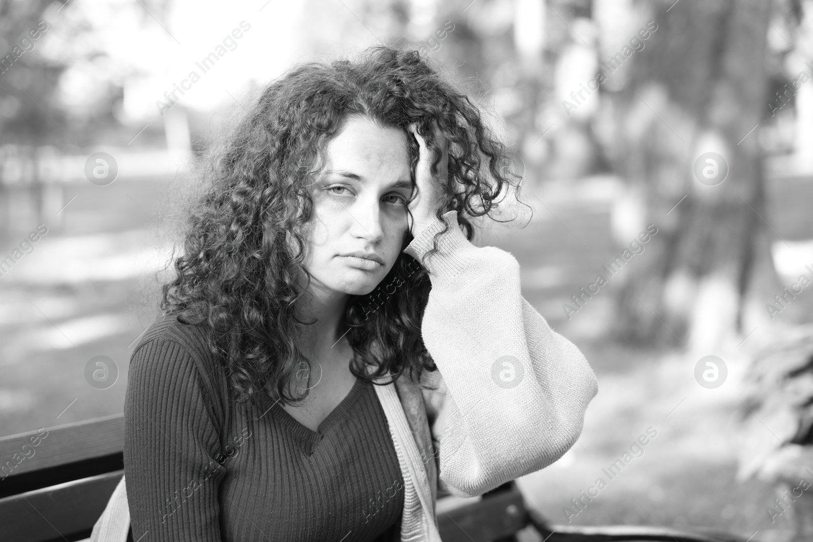 Photo of Homeless woman on bench in park, space for text. Black and white effect