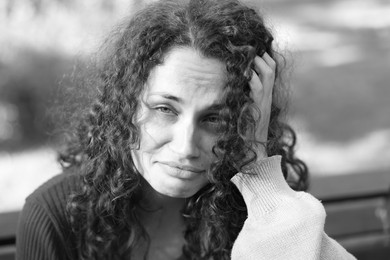 Photo of Portrait of homeless woman outdoors. Black and white effect