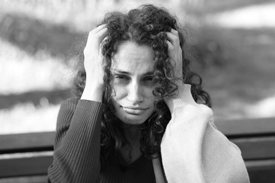 Photo of Portrait of homeless woman outdoors. Black and white effect