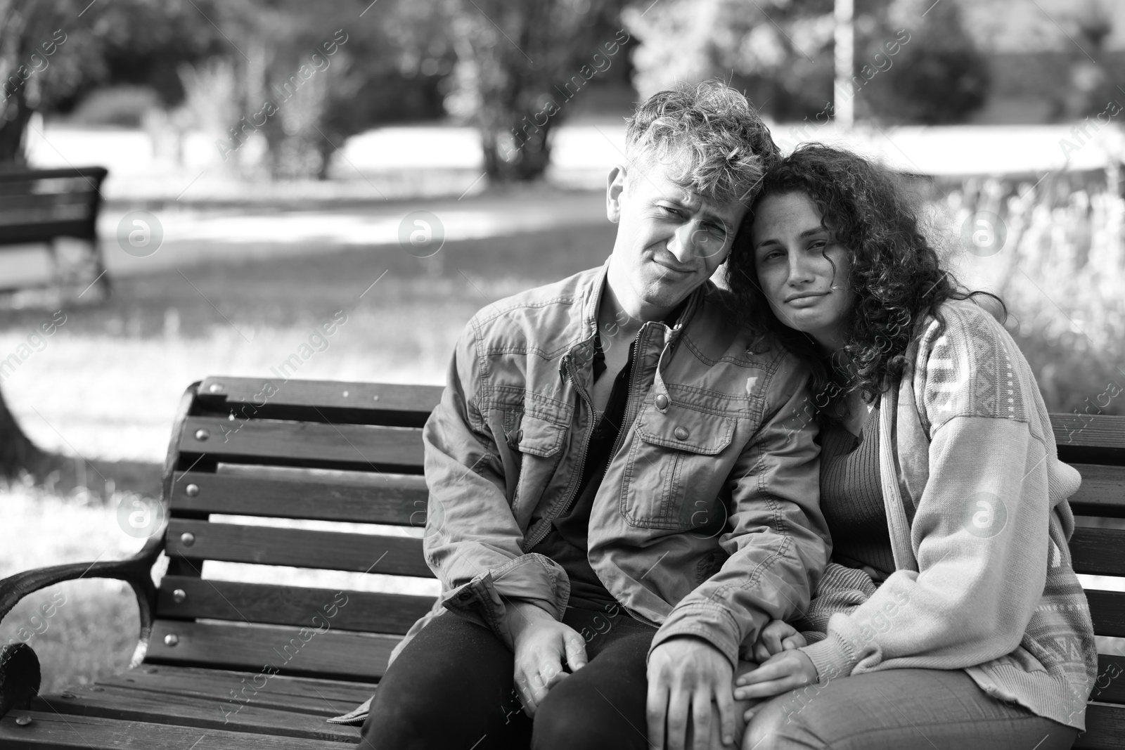 Photo of Homeless people on bench in park, space for text. Black and white effect