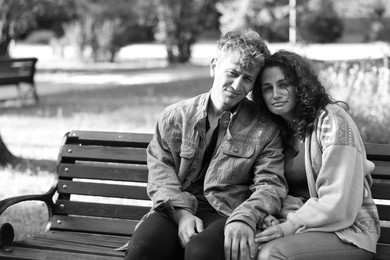 Photo of Homeless people on bench in park, space for text. Black and white effect