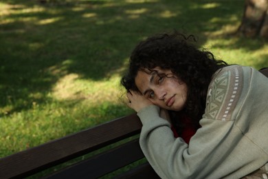 Photo of Poor homeless woman on bench in park
