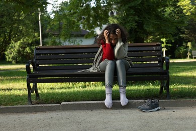 Photo of Poor homeless woman on bench in park