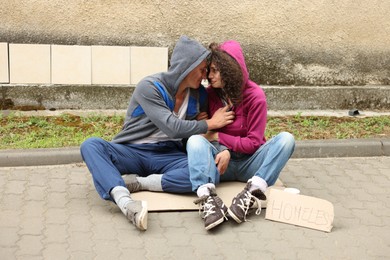 Photo of Poor people on carton and sign Homeless outdoors