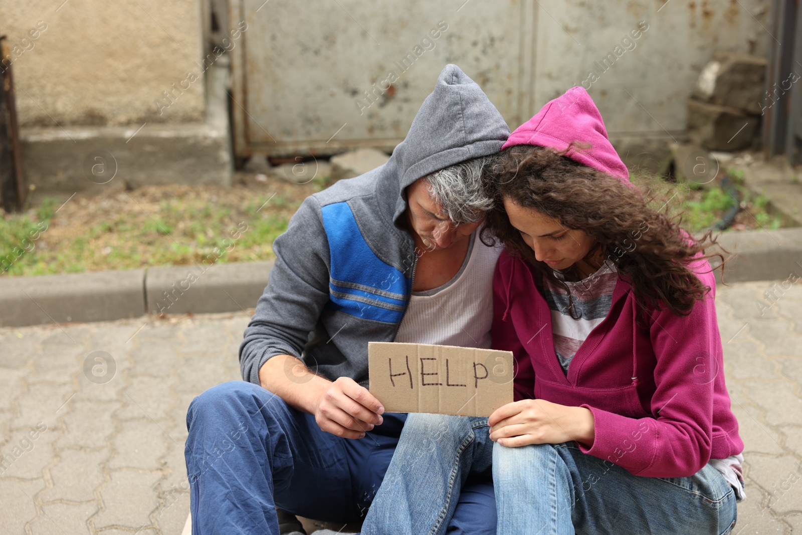 Poor homeless people with sign Help outdoors Photo of Poor homeless people with sign Help outdoors
