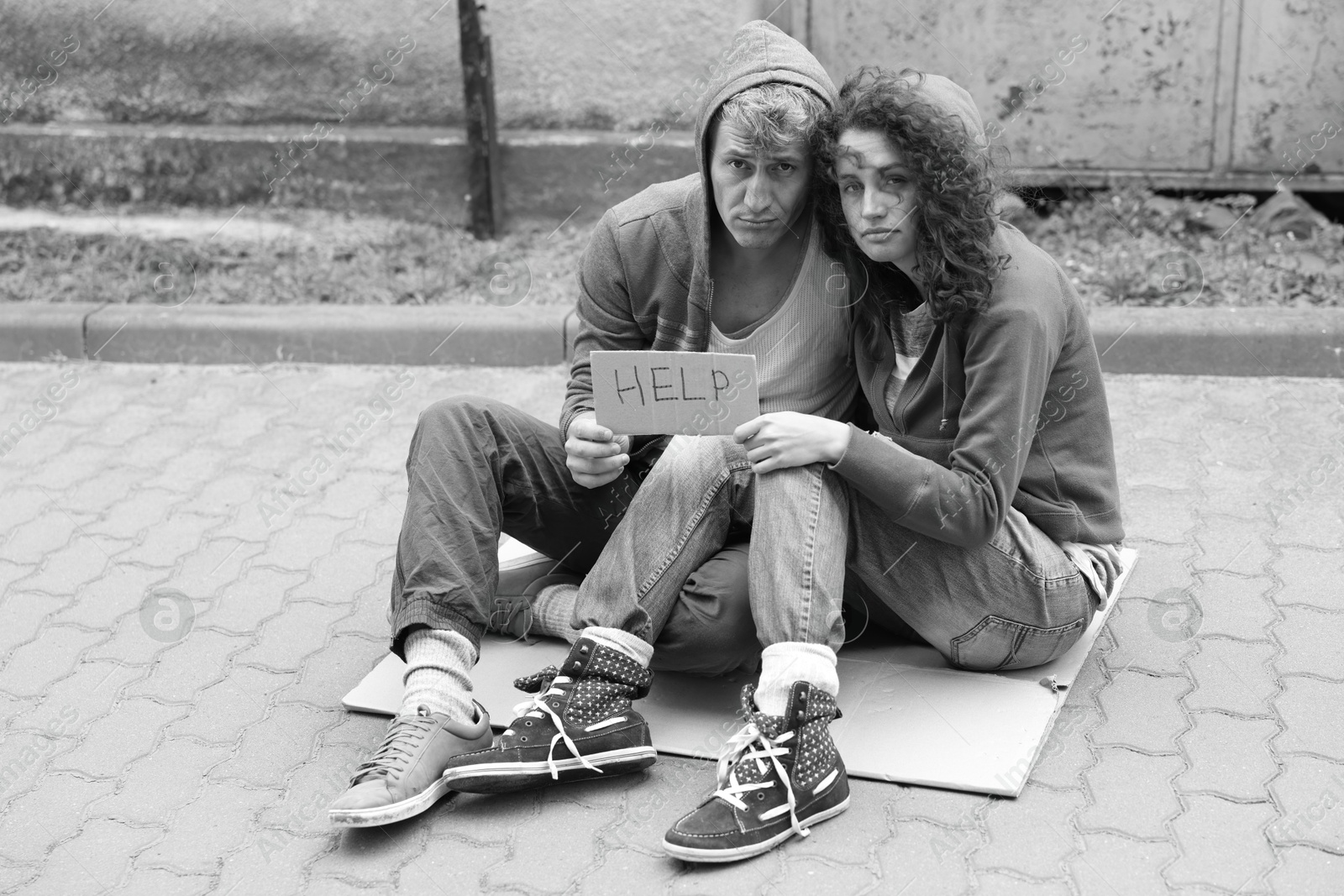 Homeless people with sign Help on carton outdoors. Black and white effect Photo of Homeless people with sign Help on carton outdoors. Black and white effect