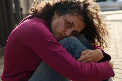 Photo of Portrait of poor homeless woman on city street