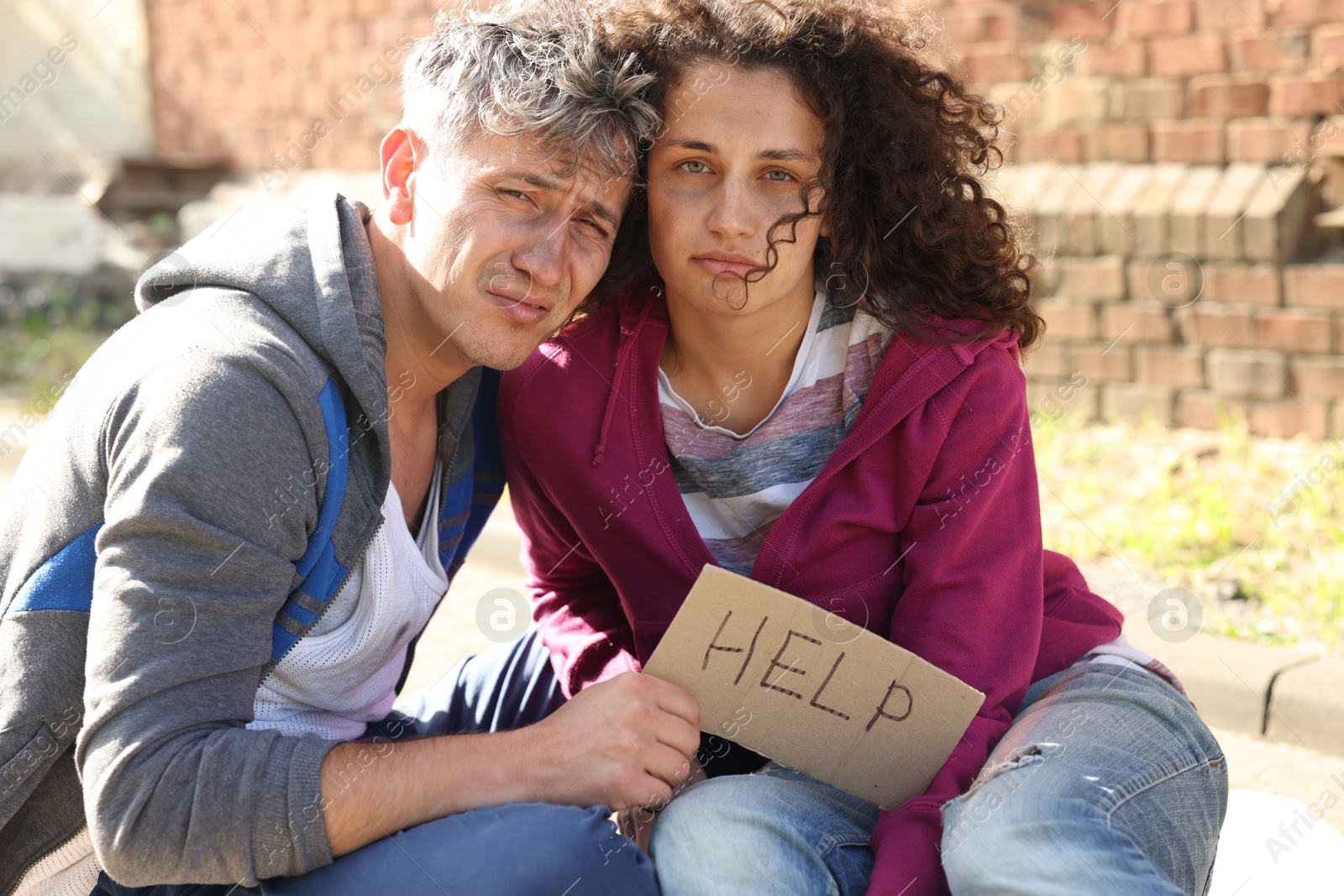 Homeless people with sign Help on city street Photo of Homeless people with sign Help on city street