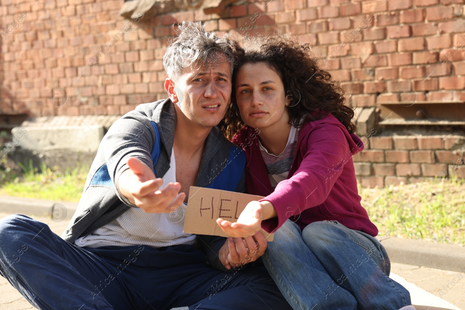 Homeless people with sign Help begging for money outdoors Photo of Homeless people with sign Help begging for money outdoors