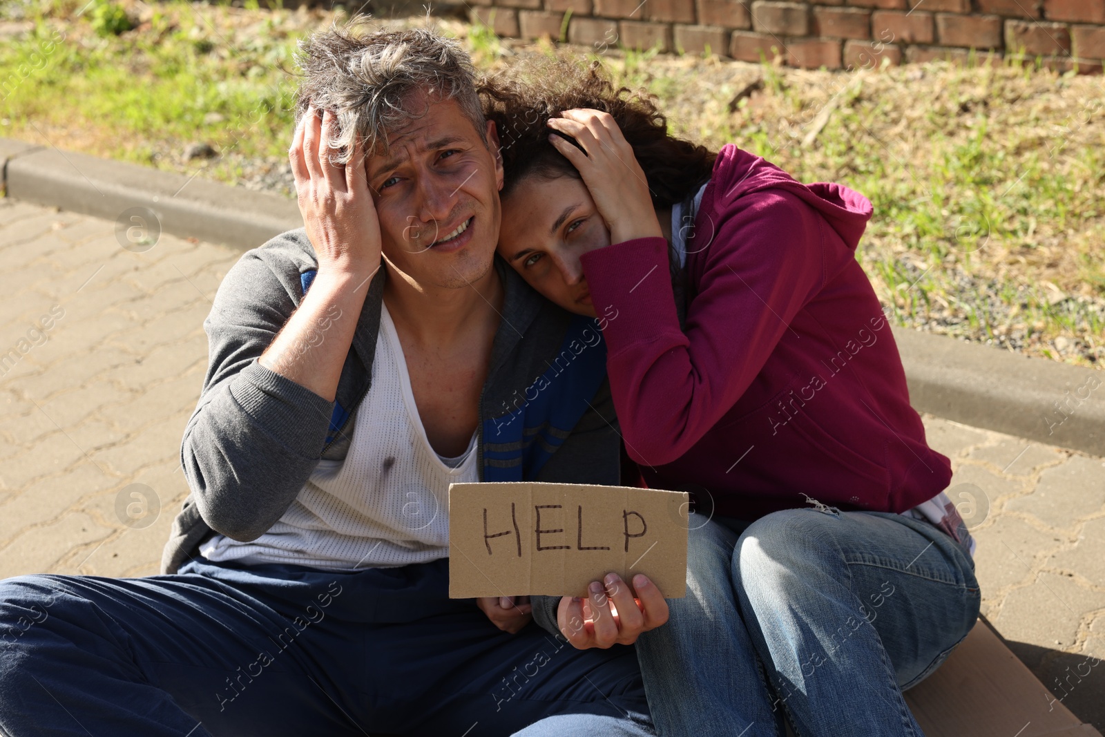 Homeless people with sign Help on city street Photo of Homeless people with sign Help on city street