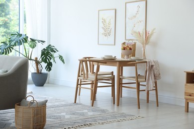 Photo of Beautiful table setting, chairs and decor in dining room. Interior design